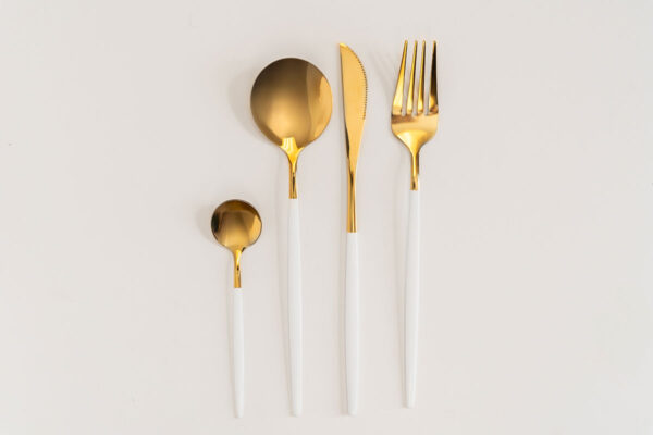 Gold & white cutlery rental set: spoons, knife, fork.
