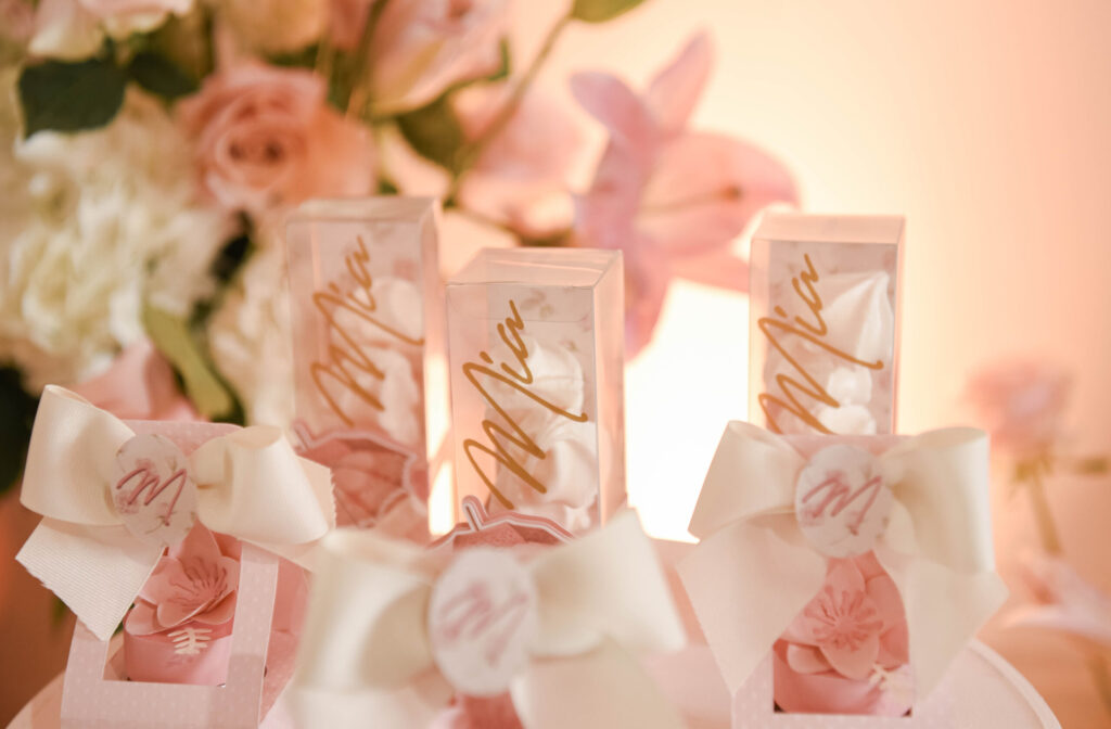 Mia's baby shower: Pink meringue favors in clear boxes with gold lettering & bows.