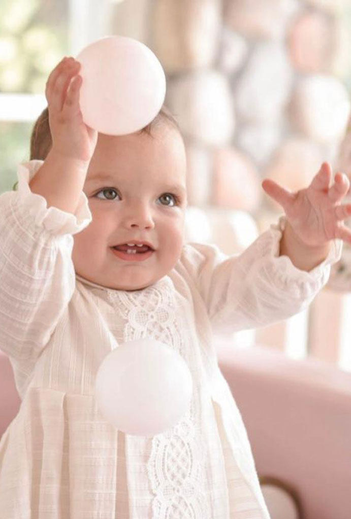 Baby girl's first birthday, playing with balloons.